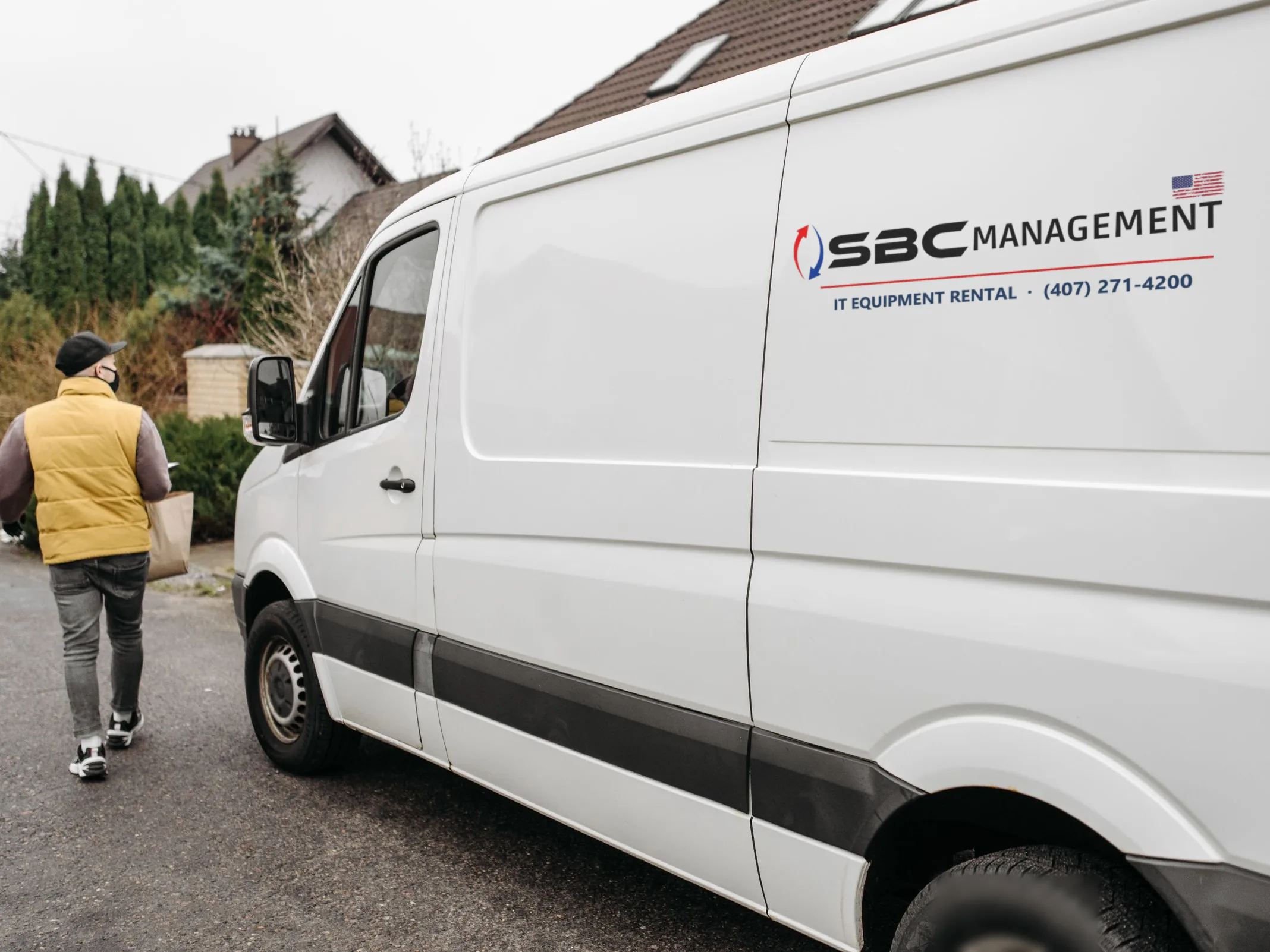 White SBC Management delivery van parked on a residential street, its driver walking to the door